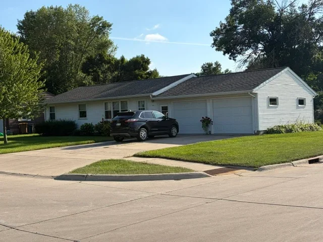 Charcoal gray asphalt shingle roof on white vinyl-sided ranch home with attached garage