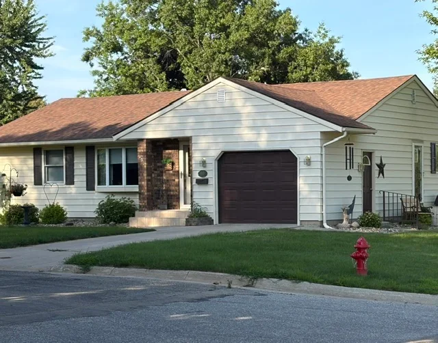 Newly installed brown architectural shingle roof on single-story home with white siding