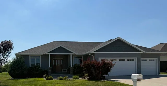 Charcoal gray asphalt shingle roof on single-story home with gable design and two-car garage
