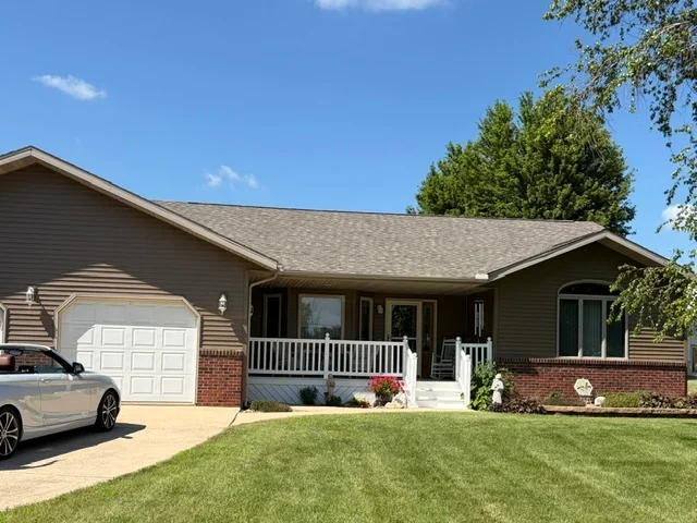 Gray architectural shingles installed on ranch home roof with brick and siding exterior