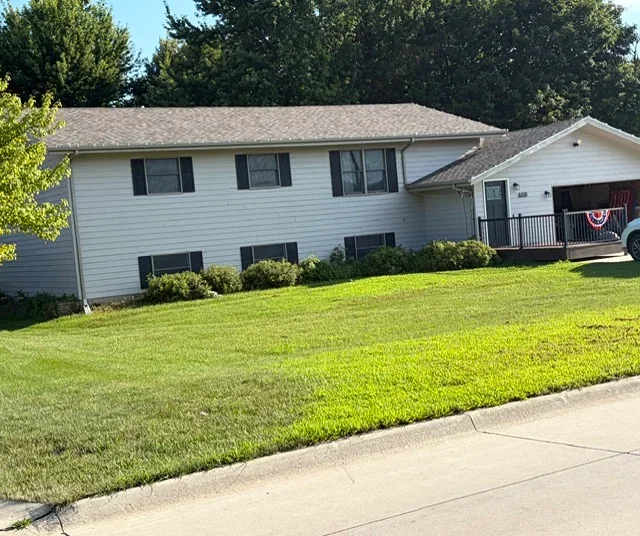 Two-story white home with new gray asphalt shingle roof and attached garage