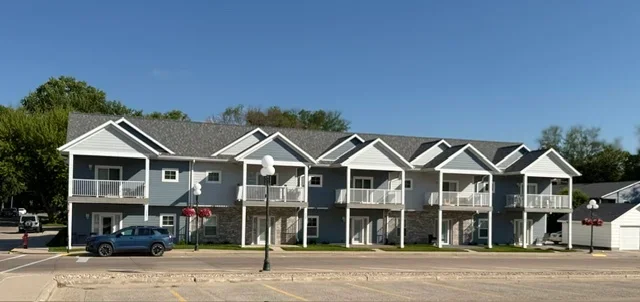 Multi-unit residential building with new asphalt shingle roofing and gable roof design